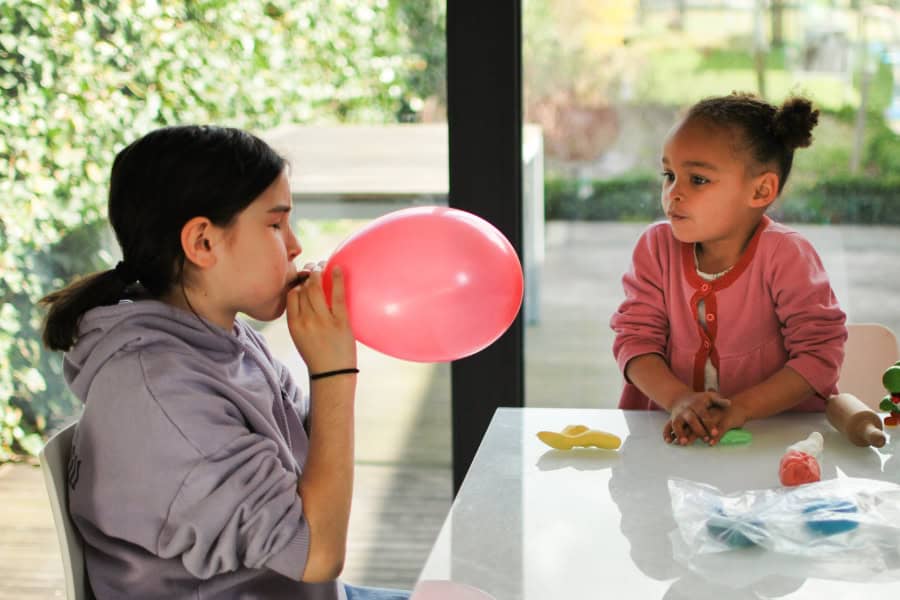 Little Girl Blowing a Ballnoon to Practice Breathing